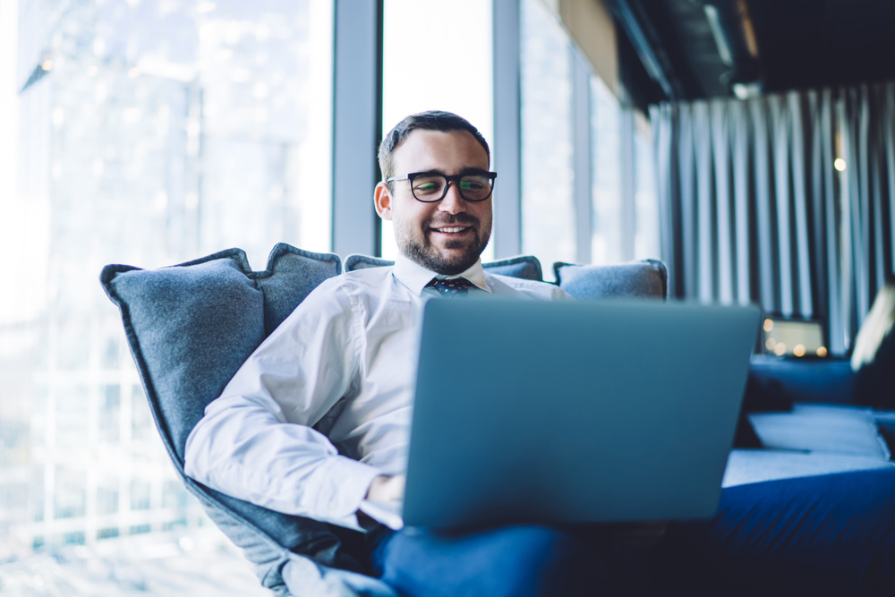 Happy,Smiling,Businessman,Having,Online,Conference,Via,Laptop,Computer,Sitting - Forex Tools Trader TradeSafer security